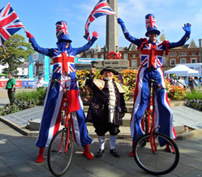 PLATINUM JUBILEE AND BEST OF BRITISH THEMED ENTERTAINMENT - union jack -best british stilt walkers-tall bike performers uk hire